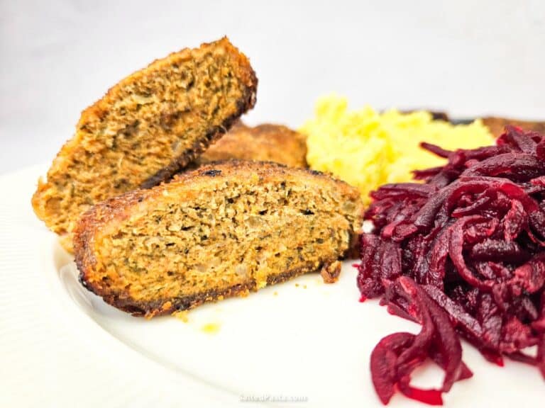 Widok przekrojonego kotleta mielonego, obok podsmażane buraki i ziemniaki puree