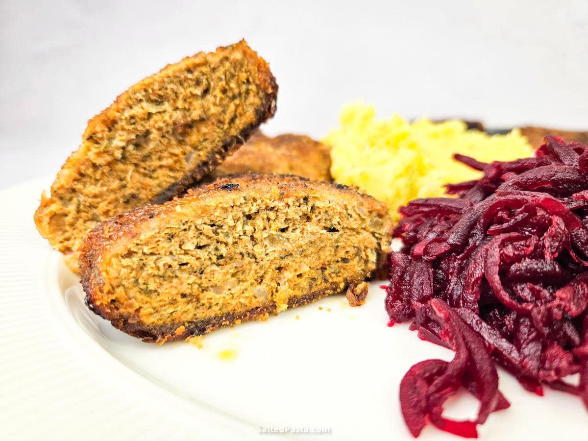 Widok przekrojonego kotleta mielonego, obok podsmażane buraki i ziemniaki puree
